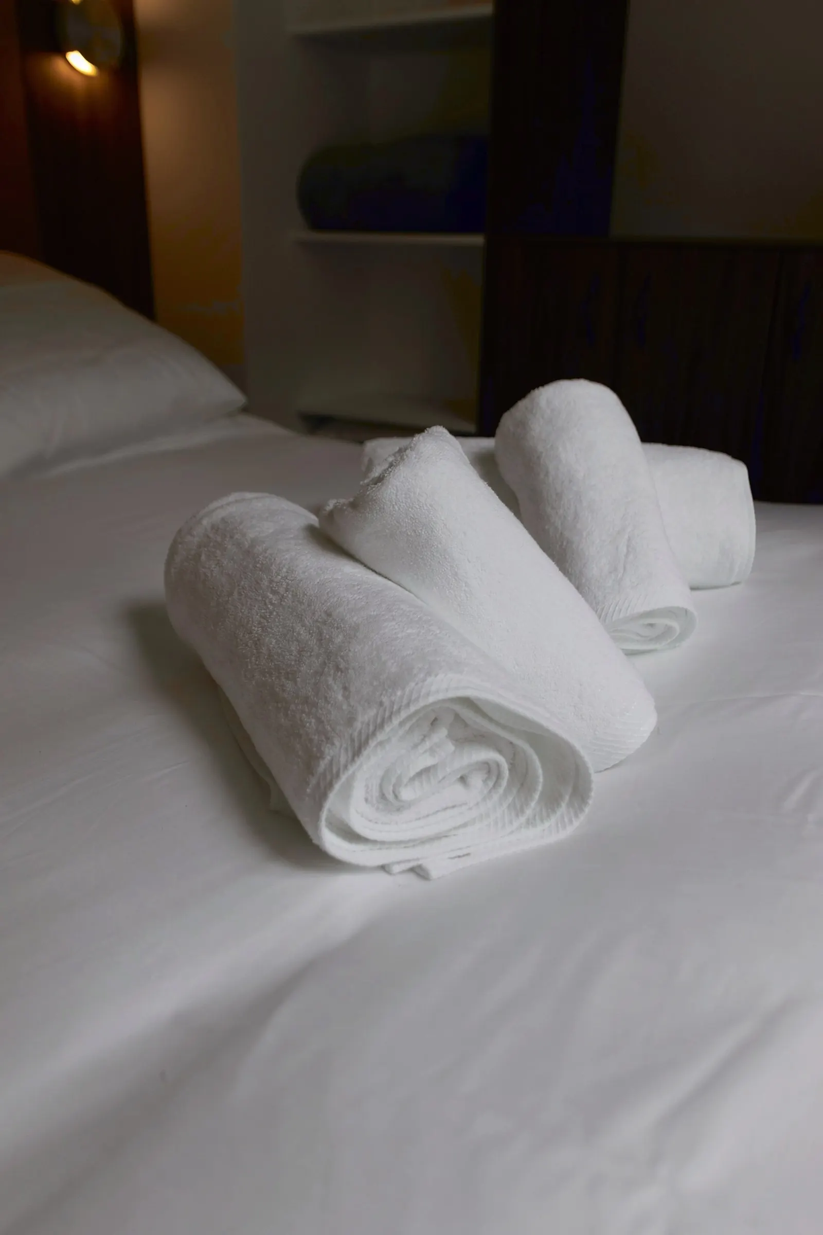 Le Gustave, furnished apartment near the Eiffel Tower, Paris 7th: rolled white towels on freshly made hotel-quality bed linen