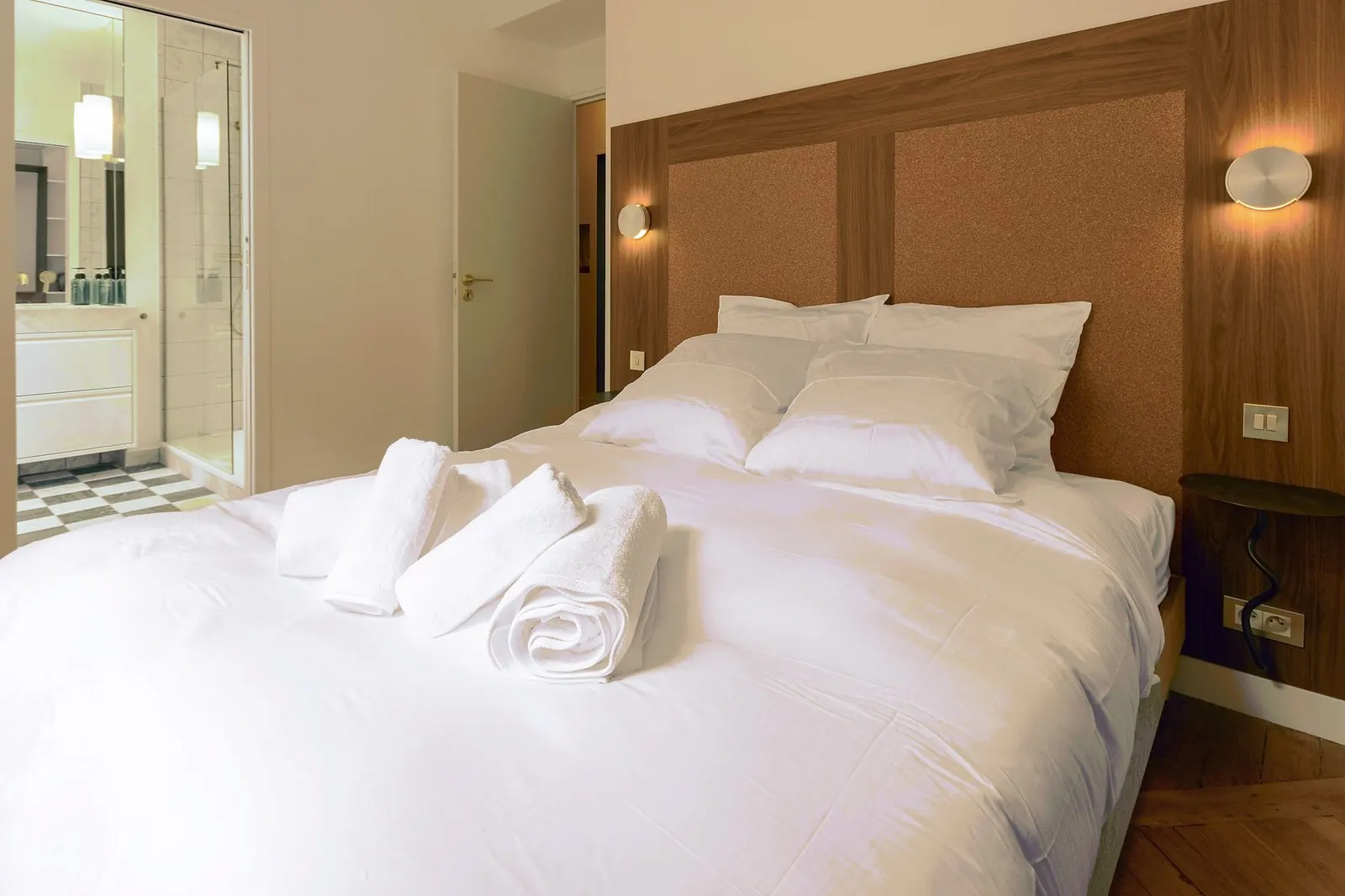 Le Gustave, furnished apartment, Paris 7th: bedroom with wooden headboard and en-suite bathroom