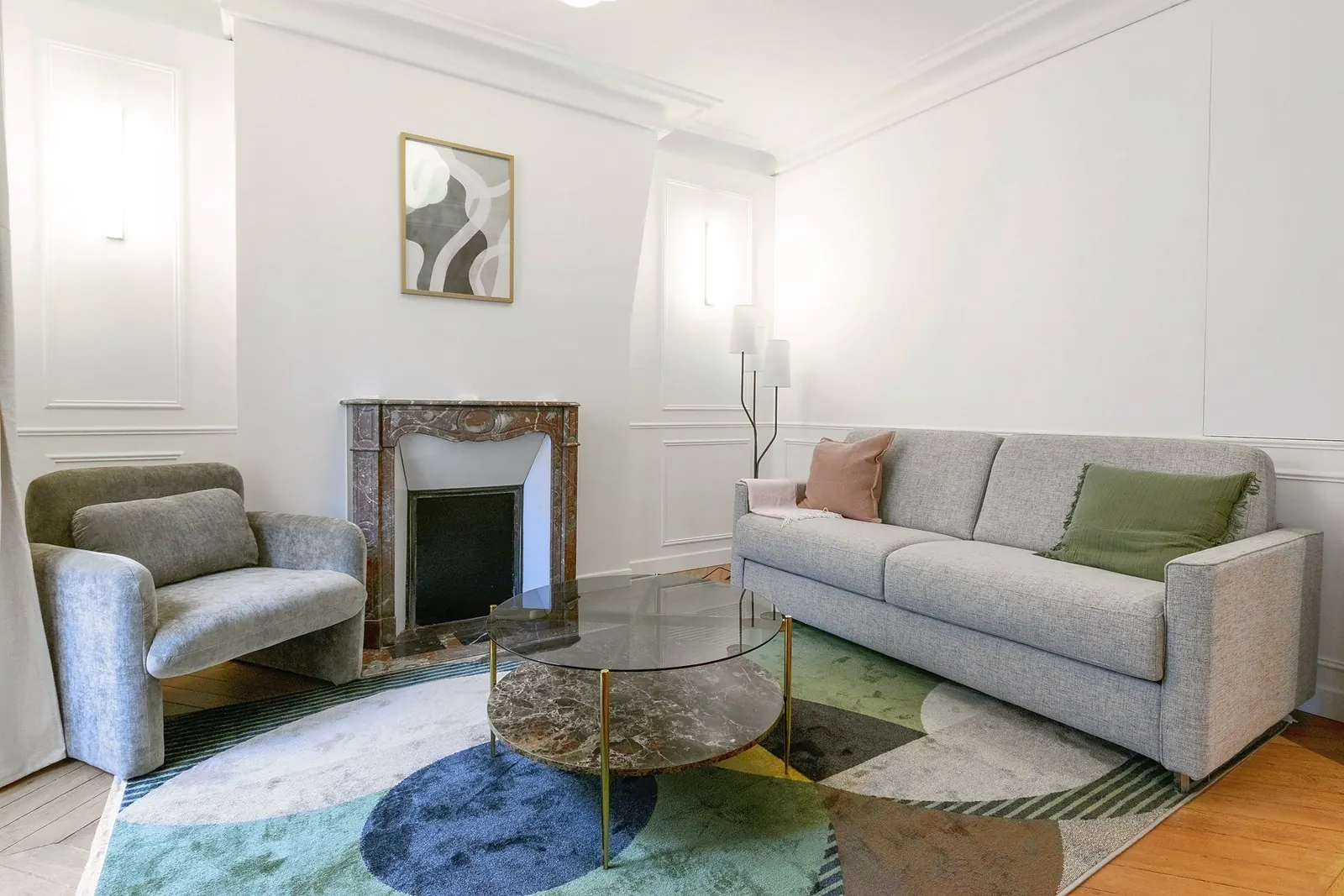 Le Gustave, furnished apartment near the Eiffel Tower, Paris 7th: living room with Haussmann mouldings, marble fireplace, armchair and sofa