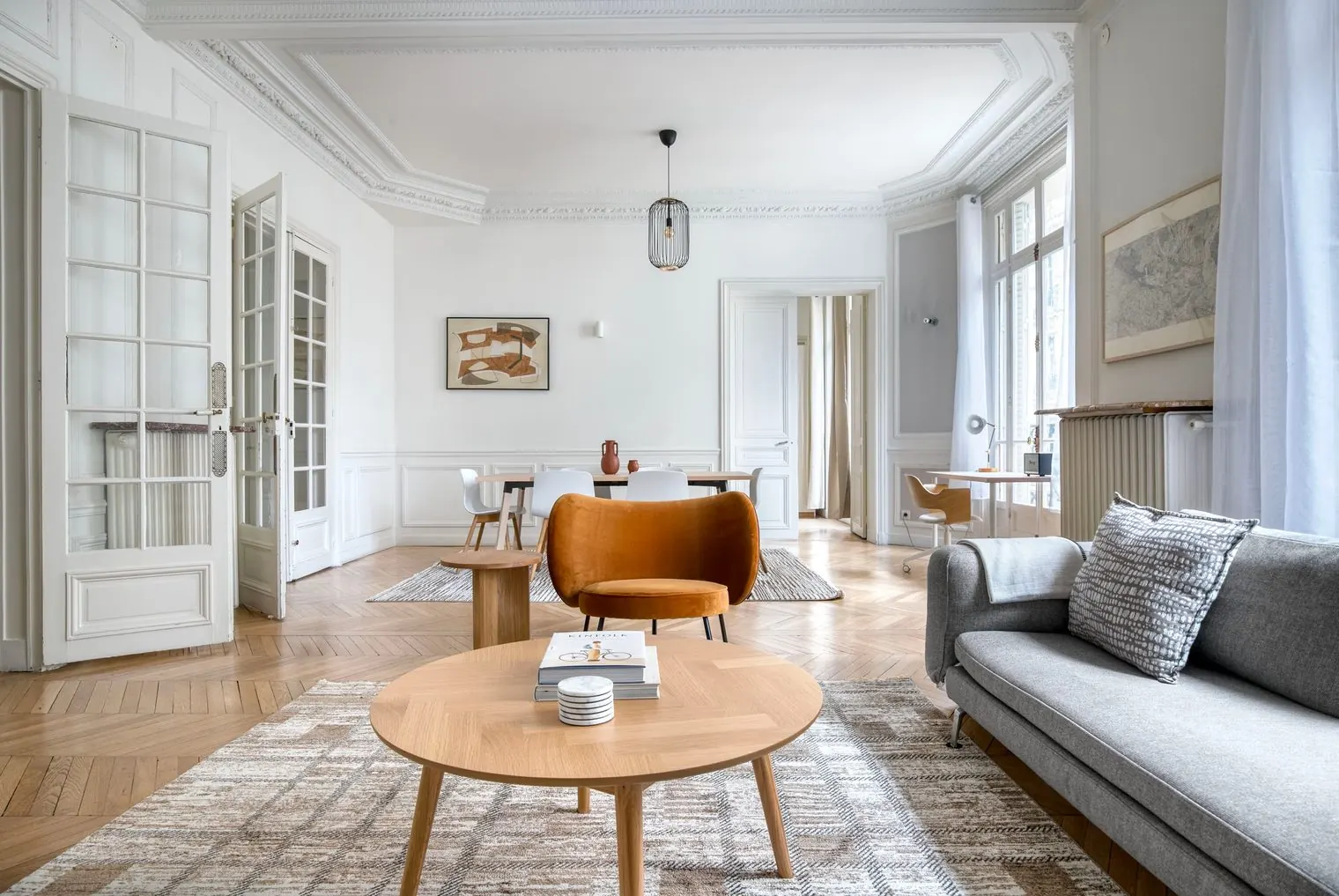 Le Monceau, furnished three-bedroom apartment near Parc Monceau, Paris 17th: the living room with Haussmann mouldings, fireplace and two sofas