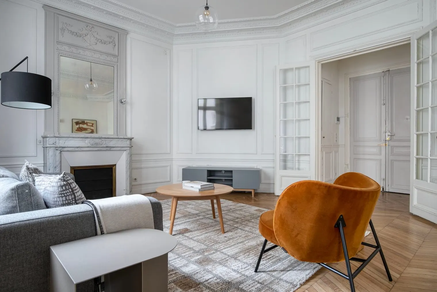 Le Monceau, furnished apartment, Paris 17th: living room, fireplace and orange armchair